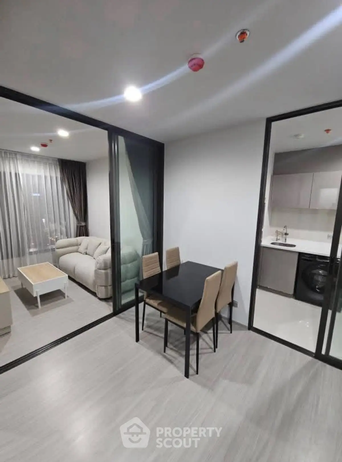 Modern apartment with open layout, featuring a cozy living room and sleek kitchen area.