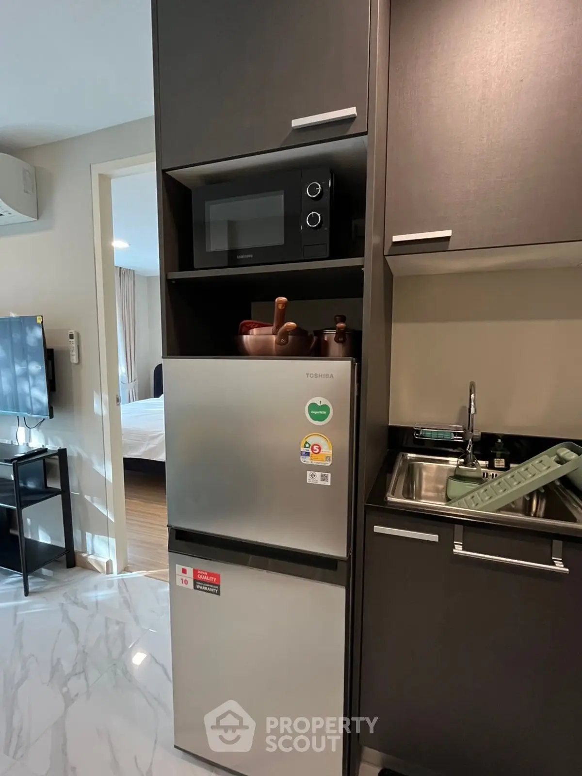 Modern kitchen with sleek appliances and stylish cabinetry in a cozy apartment setting.