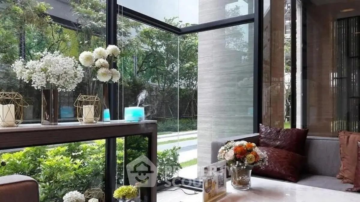Luxurious living room with large windows and elegant decor overlooking a lush garden.