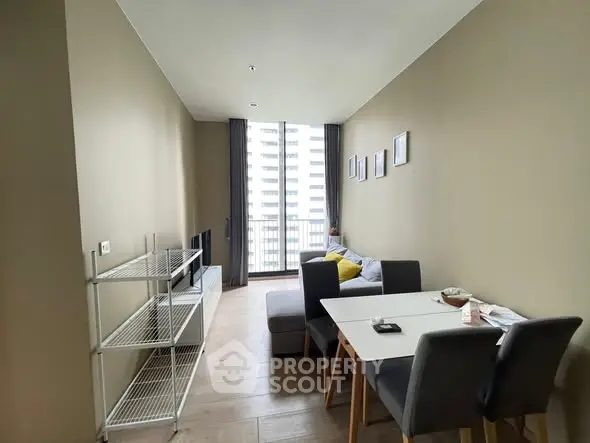 Modern living room with dining area and large window view in urban apartment.