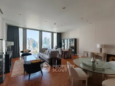 Spacious living room with city view, elegant furniture, and natural light.