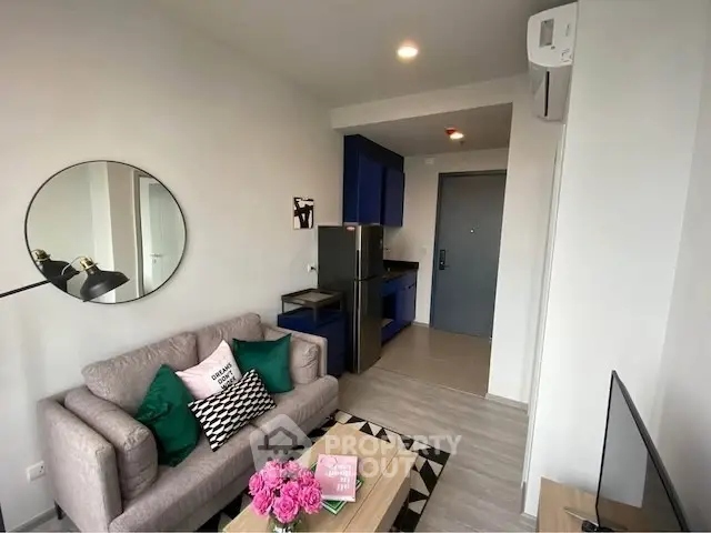 Modern living room with stylish decor and compact kitchen area, perfect for urban living.