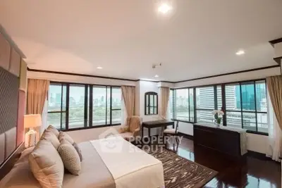 Luxurious bedroom with city view, elegant decor, and ample natural light.
