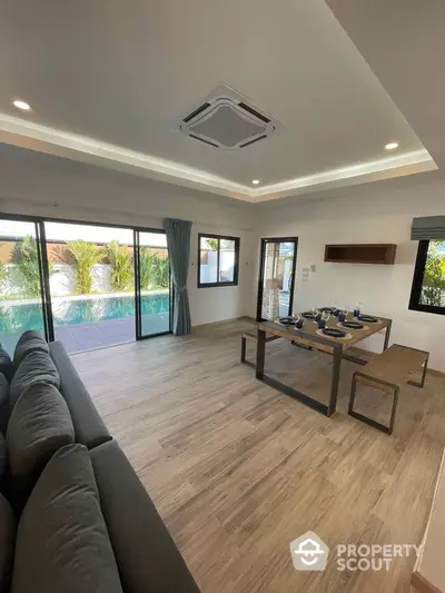 Modern living room with pool view and stylish dining area