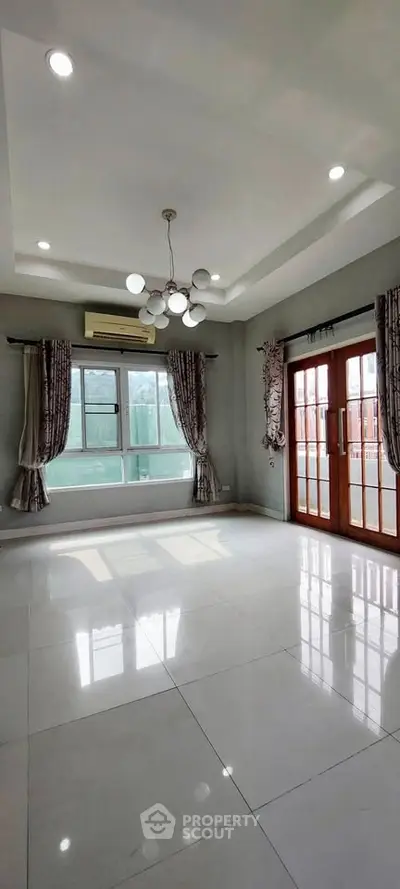 Spacious living room with modern lighting and large windows for natural light.