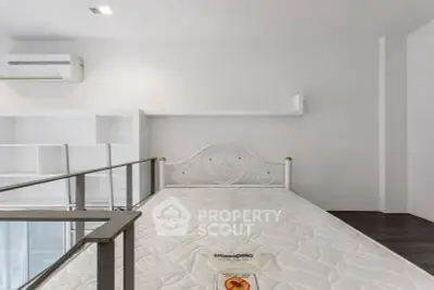 Modern bedroom with loft-style design and air conditioning unit.