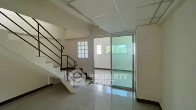 Spacious interior with modern staircase and sliding glass door, ideal for versatile living space.