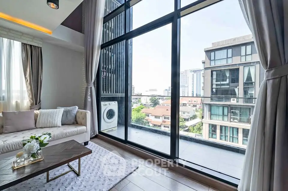 Spacious living room with large windows offering stunning city views and modern decor.