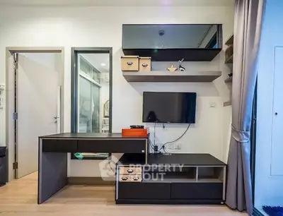 Modern study area with sleek desk and wall-mounted TV in stylish apartment.