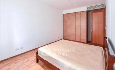 Spacious bedroom with wooden flooring and built-in wardrobe