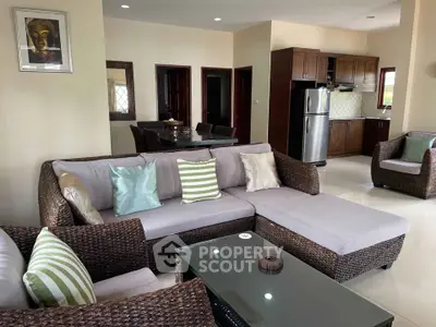 Spacious living room with modern wicker furniture and open kitchen layout