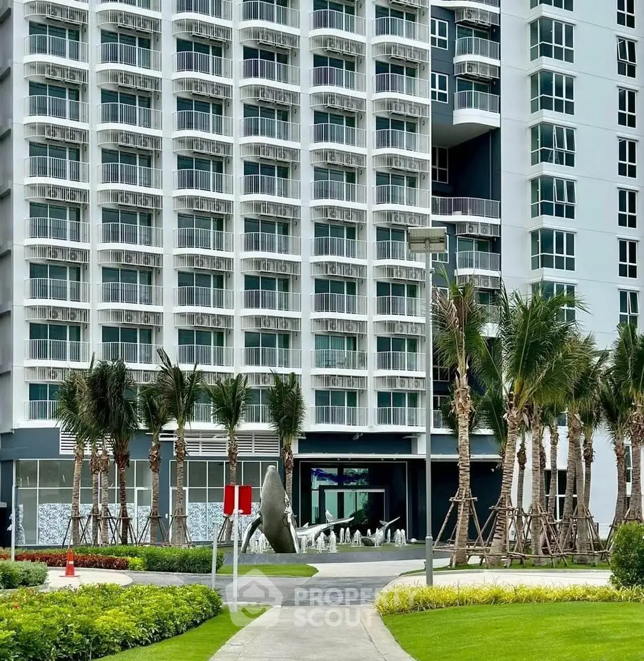 Modern high-rise building with lush landscaping and palm trees, showcasing contemporary urban living.