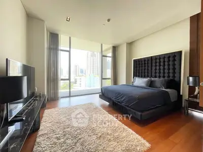 Luxurious bedroom with city view, modern furnishings, and elegant decor in high-rise apartment.