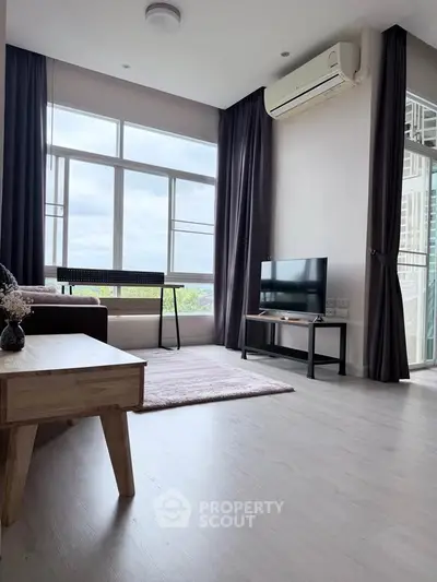 Modern living room with large windows and air conditioning, featuring stylish furniture and a serene view.