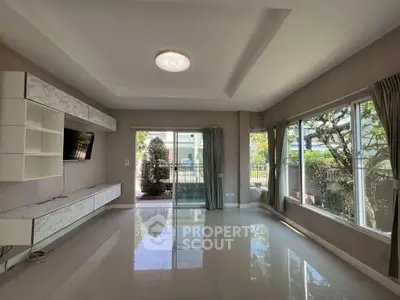 Spacious living room with large windows and modern design, perfect for natural light lovers.