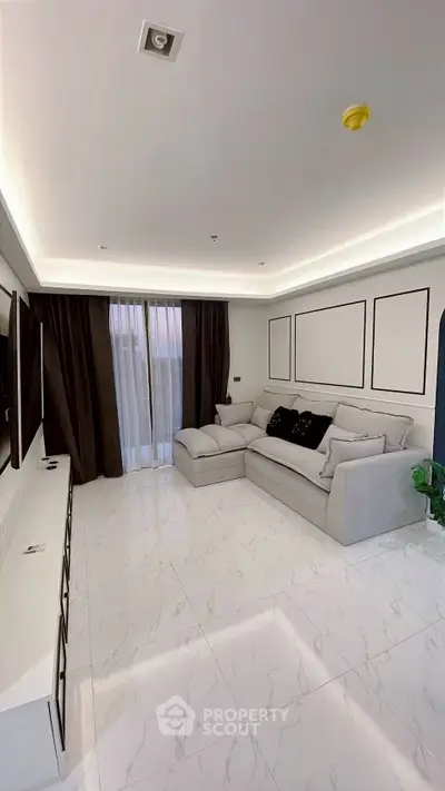 Modern living room with sleek design, featuring a spacious sofa and elegant marble flooring.