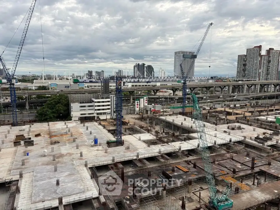 Urban construction site with cranes and city skyline in the background, showcasing modern development.