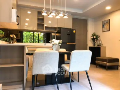 Modern kitchen with open layout and elegant dining area, featuring stylish lighting and contemporary decor.