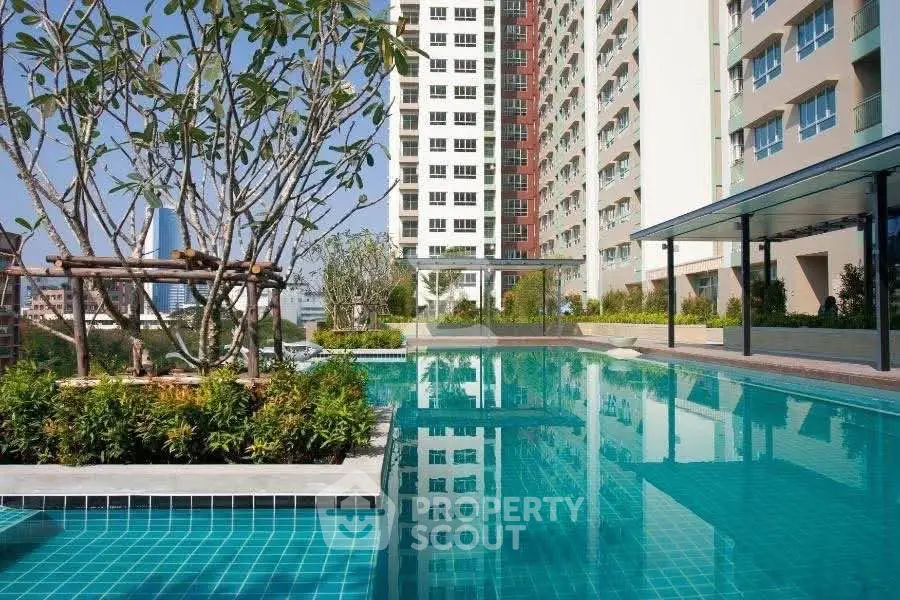Luxurious apartment complex with stunning outdoor pool and lush greenery.