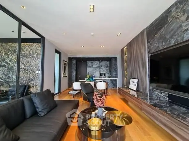 Luxurious modern living room with sleek black sofa and elegant marble accents.