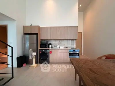Modern kitchen with sleek cabinetry, stainless steel appliances, and spacious dining area in open layout.