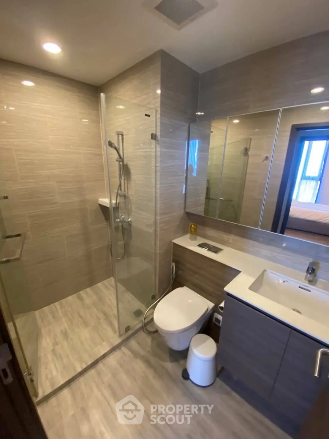 Modern bathroom with glass shower and sleek fixtures in contemporary apartment.