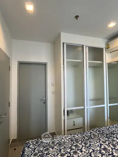 Modern bedroom with built-in wardrobe and air conditioning in a stylish apartment.