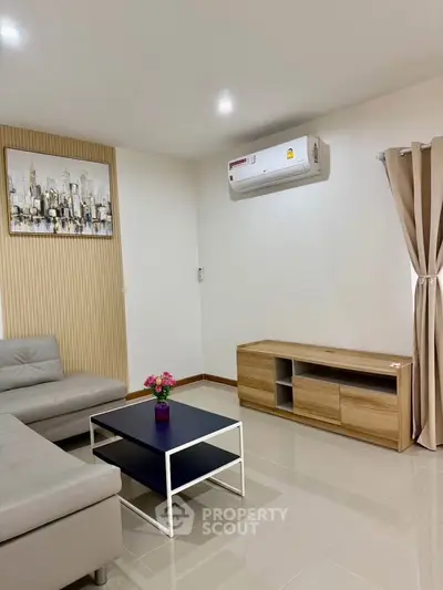 Modern living room with sleek furniture and air conditioning, perfect for comfortable living.
