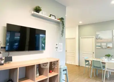 Modern living room with wall-mounted TV and stylish dining area