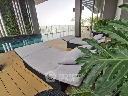 Luxurious rooftop pool area with stylish loungers and city view, perfect for relaxation and leisure.