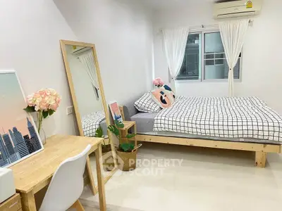 Modern bedroom with stylish decor, featuring a cozy bed, desk, and large mirror, perfect for urban living.