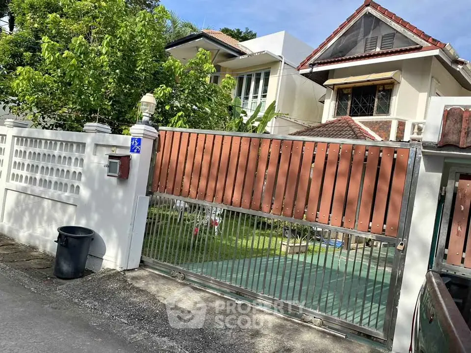 Charming residential property with gated entrance and lush greenery