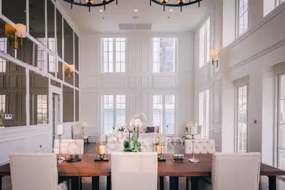 Luxurious high-ceiling living room with elegant dining area and large windows