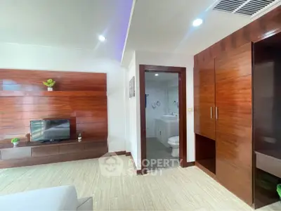 Modern living room with wooden accents and open view to bathroom
