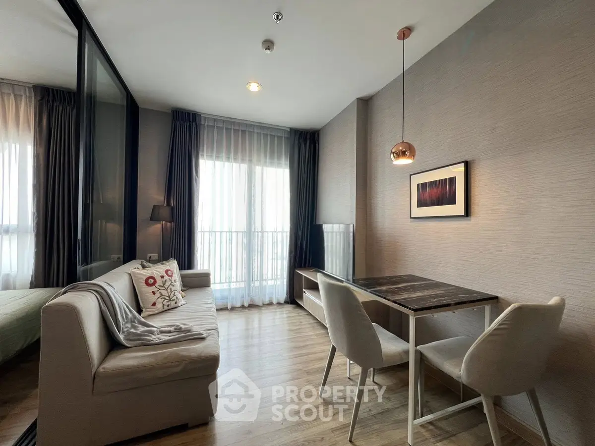 Modern living room with stylish decor and natural light, featuring a cozy sofa and dining area.