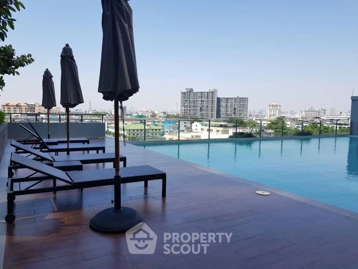 Stunning rooftop pool with city skyline views and modern lounge chairs.