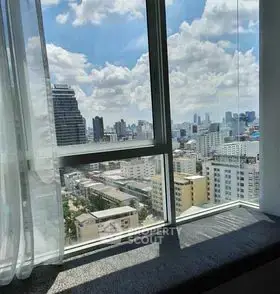 Stunning cityscape view from a modern apartment window with clear blue skies.