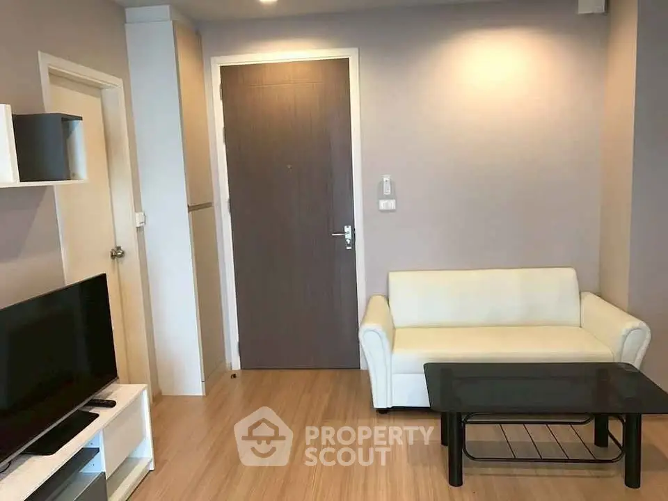 Modern living room with sleek furniture and wooden flooring in a stylish apartment.
