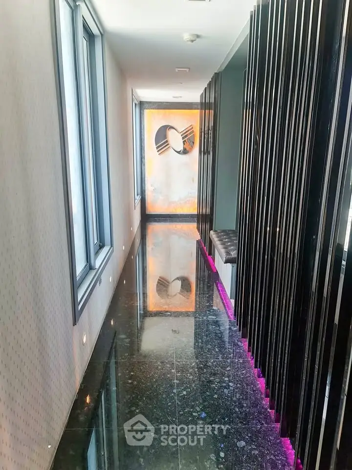 Sleek modern corridor with glossy floors and artistic wall decor in luxury building.