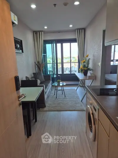 Modern apartment interior with open layout, featuring a cozy living area and balcony view.