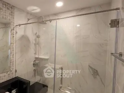 Modern bathroom with elegant marble tiles and glass shower enclosure