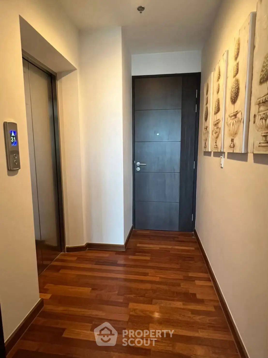 Elegant apartment entrance with wooden flooring and modern elevator access.
