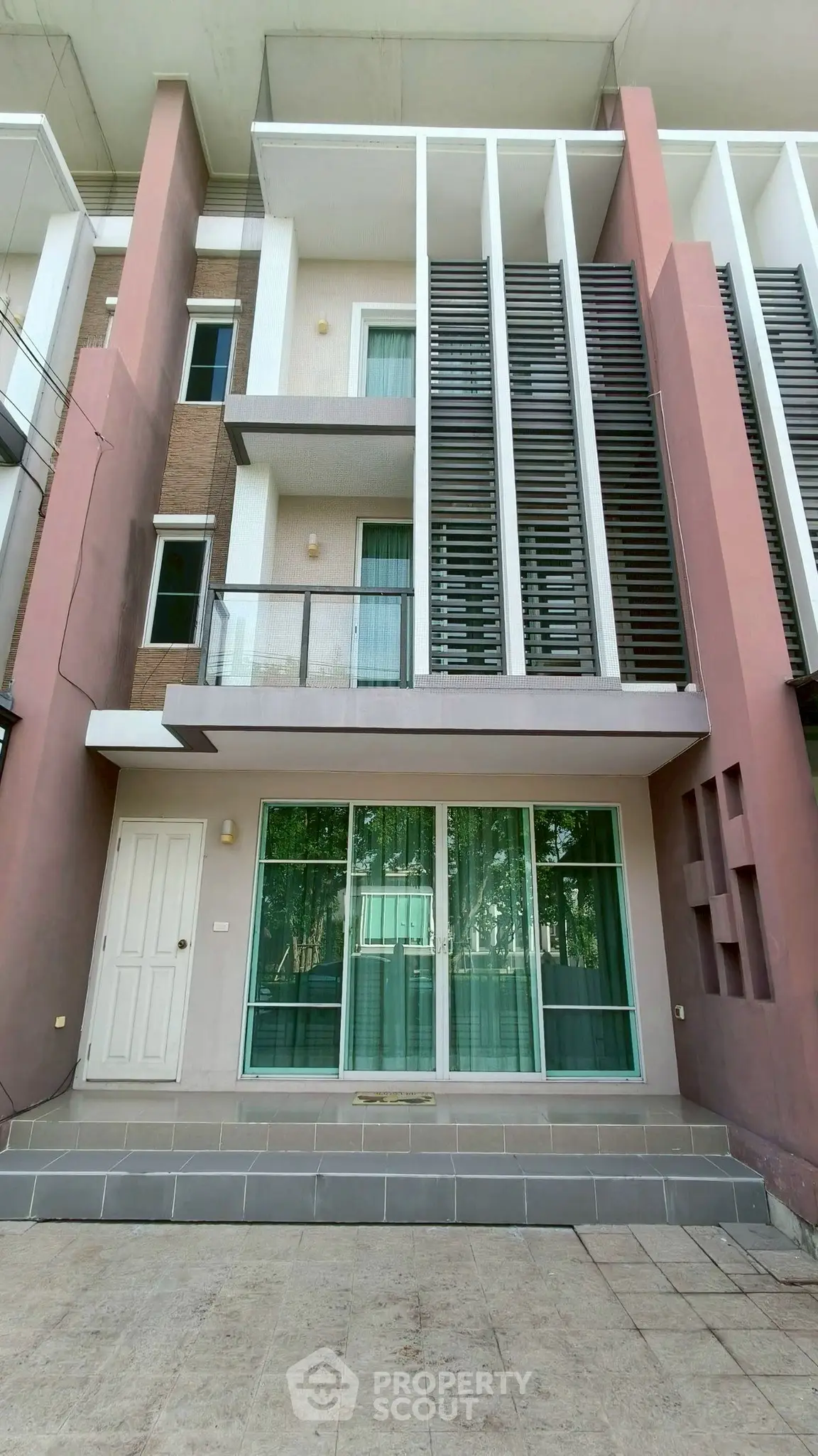 Modern multi-story building exterior with large windows and stylish facade design.