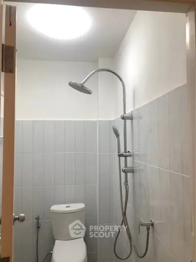 Modern bathroom with sleek shower and toilet in a minimalist design.