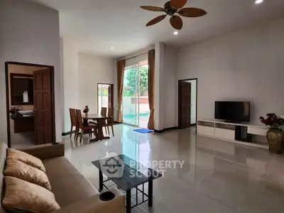 Spacious living room with pool view, modern decor, and elegant furniture