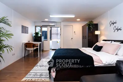 Spacious modern bedroom with stylish decor and natural light, perfect for urban living.