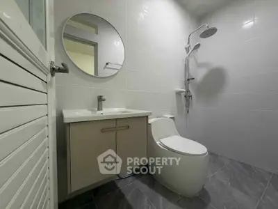 Modern bathroom with sleek fixtures and round mirror in a contemporary home.