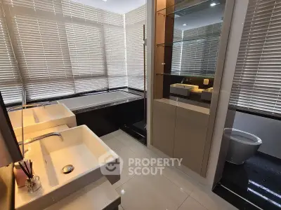 Luxurious modern bathroom with dual sinks and large bathtub, featuring sleek design and ample natural light.