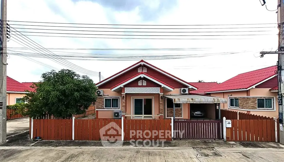 Charming single-story house with red roof and fenced yard in a serene neighborhood.