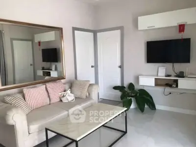 Modern living room with stylish sofa, wall-mounted TV, and elegant decor.